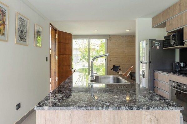 A modern kitchen with a granite countertop, stainless steel sink, and built-in appliances.