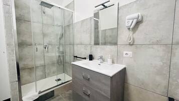 Habitación Deluxe | Baño | Regadera, regadera tipo lluvia, secadora de cabello, batas