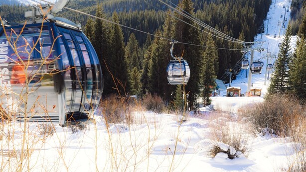 A ski lift with cabins moving along a snowy mountain path, surrounded by dense forest. - Wild Irishman Off-Piste Condo: Great Keystone Getaway (Keystone)