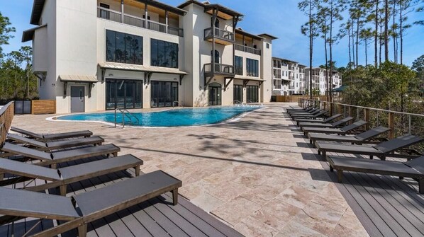 A poolside area with lounge chairs and a swimming pool.