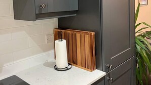 A modern kitchen with dark grey cabinets, a white countertop, and a built-in stove. - Modern and Spacious 2 Bedroom Flat Near Shoreditch (London)