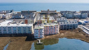 Un hotel costero con varias edificaciones, incluyendo un edificio principal de techo plano y otras estructuras más pequeñas con tejados coloridos.