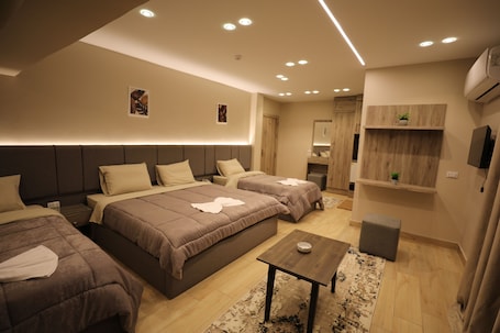 Deluxe Quadruple Room | Minibar, in-room safe, desk, laptop workspace. Holy Sheet Plus, Boutique Hotel