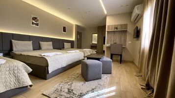 Deluxe Quadruple Room, Multiple Beds | Minibar, in-room safe, desk, laptop workspace