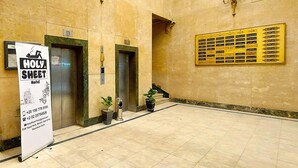 A lobby with two elevators, a reception desk, and a sign for the Holy Sheet Hotel. - Holy Sheet Plus, Boutique Hotel (Cairo)