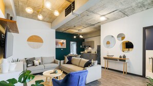 A modern living room with a sofa, armchair, and coffee table, a kitchen area with cabinets and appliances, and a dining table with chairs. - Vivo One Zona 1 Guatemala (Guatemala City)