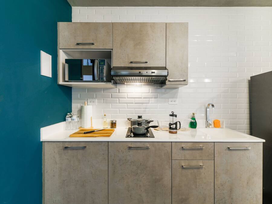A modern kitchen with a microwave, stove, and various kitchen items on the counter.