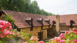 Ein traditionelles Steinhaus mit Ziegeldach und mehreren Dachfenstern.
