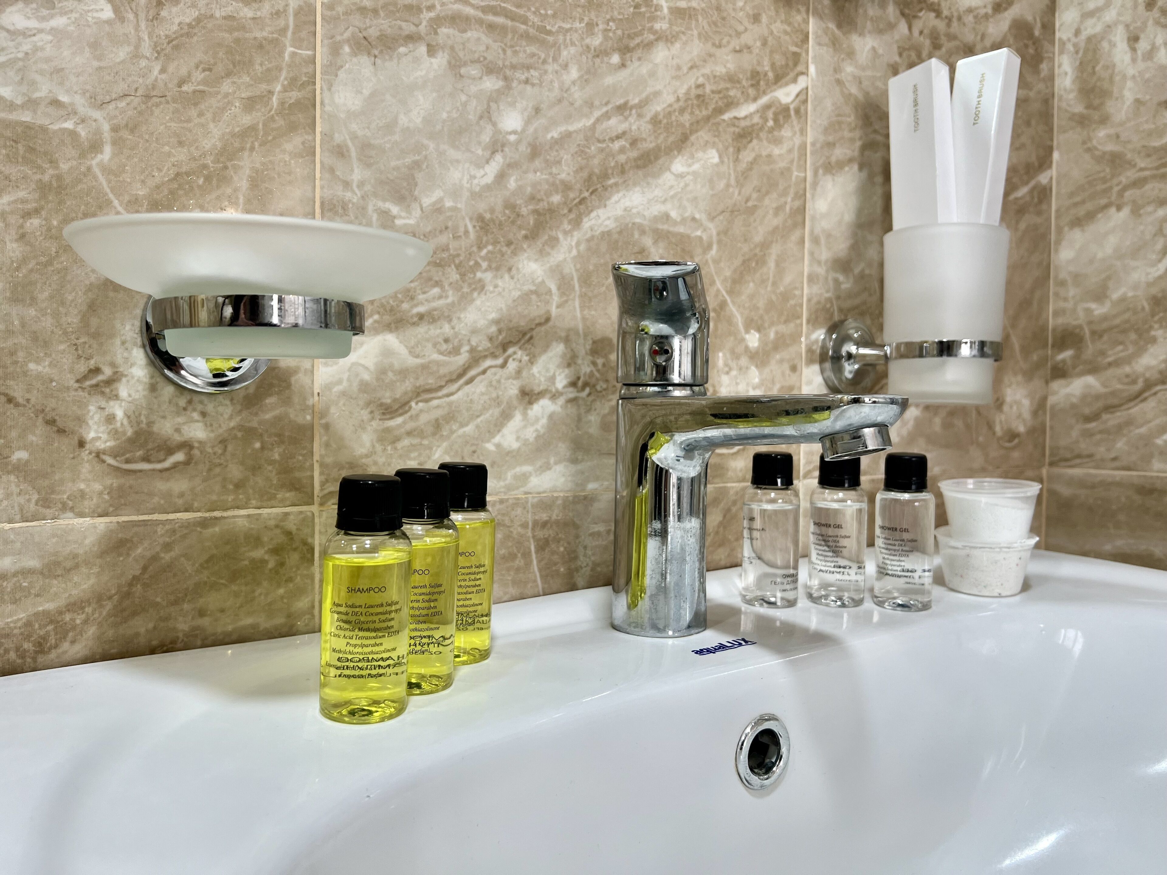 A bathroom sink with toiletries, a mirror, and a faucet.