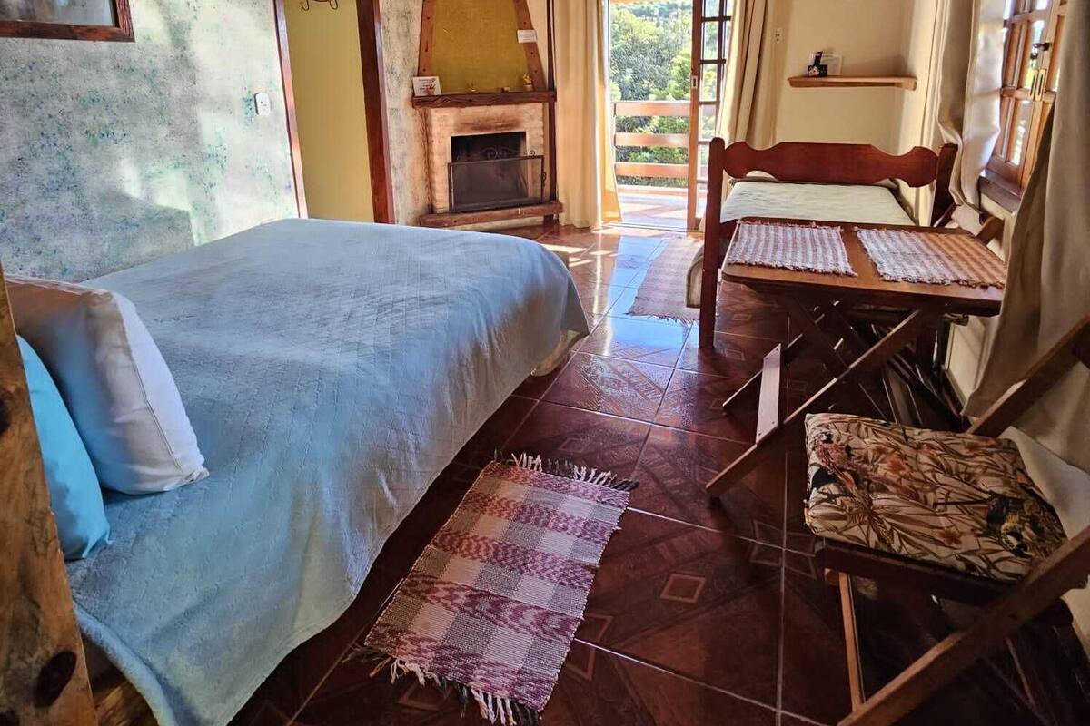 Ein gemütliches Zimmer mit einem Bett, einem Tisch und einem Kamin.