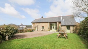 A stone house with a paved driveway and a grassy lawn. - Wheelhouse (Barnstaple)