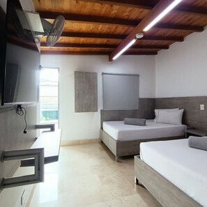 A modern bedroom with a wooden ceiling, a bed, a TV, and a window. - HOTEL INN CARIBE (Medellín)
