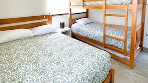 A room with two bunk beds, a bedside table with a lamp, and a window with blinds. - HOP Encanto Exclusiva de Campo en Pisco (El Carmen)
