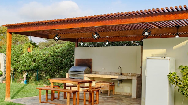 An outdoor patio with a grill, table, and benches. - HOP Ohana Exclusiva en Campo y Playa en Chincha (El Carmen)