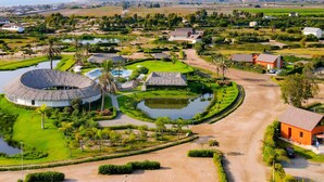 A resort with circular buildings, a central water feature, and a well-maintained landscape. - HOP Bali Exclusiva Laguna y Playa en Chincha (El Carmen)