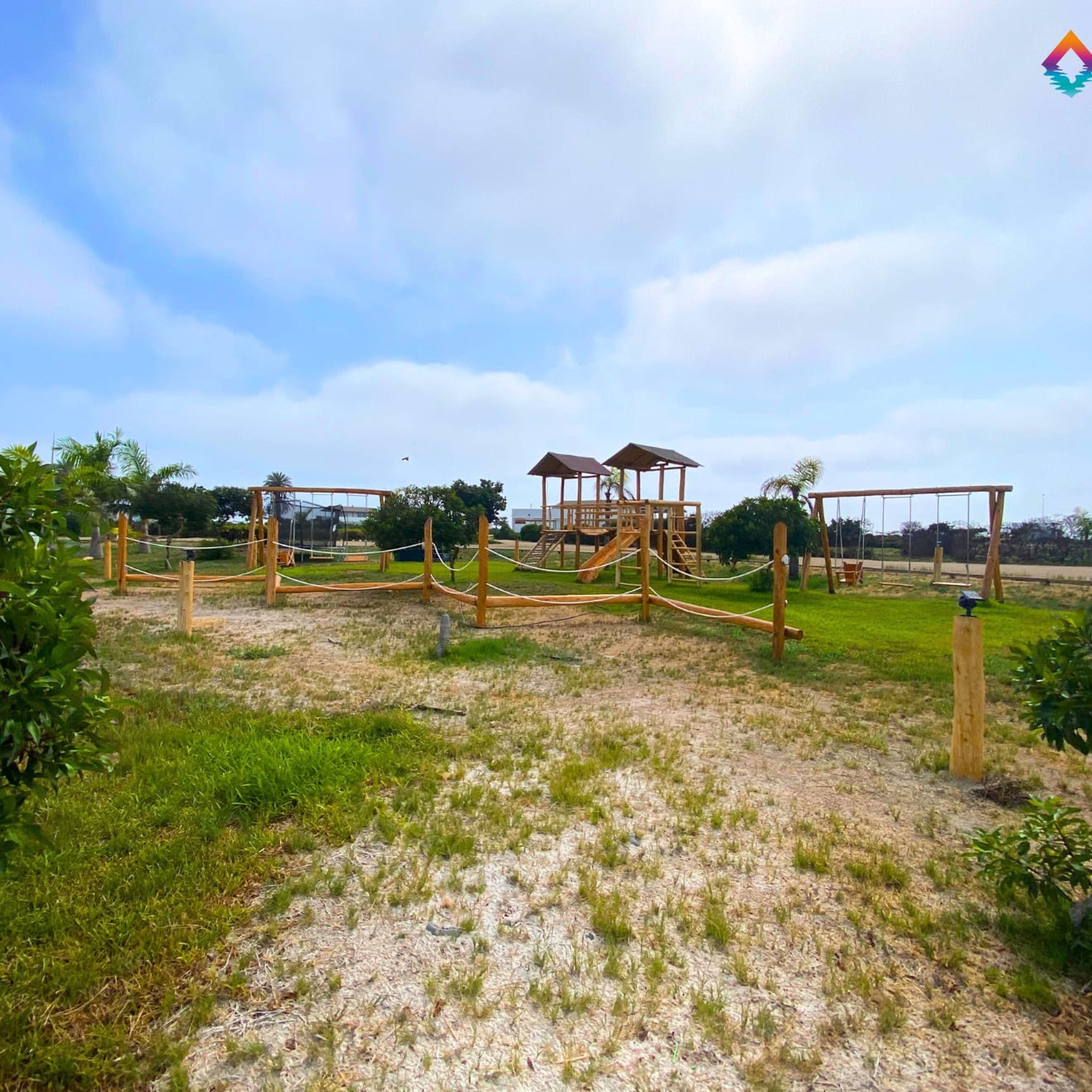 Ein Spielplatz mit Holzkonstruktionen und Schaukeln.