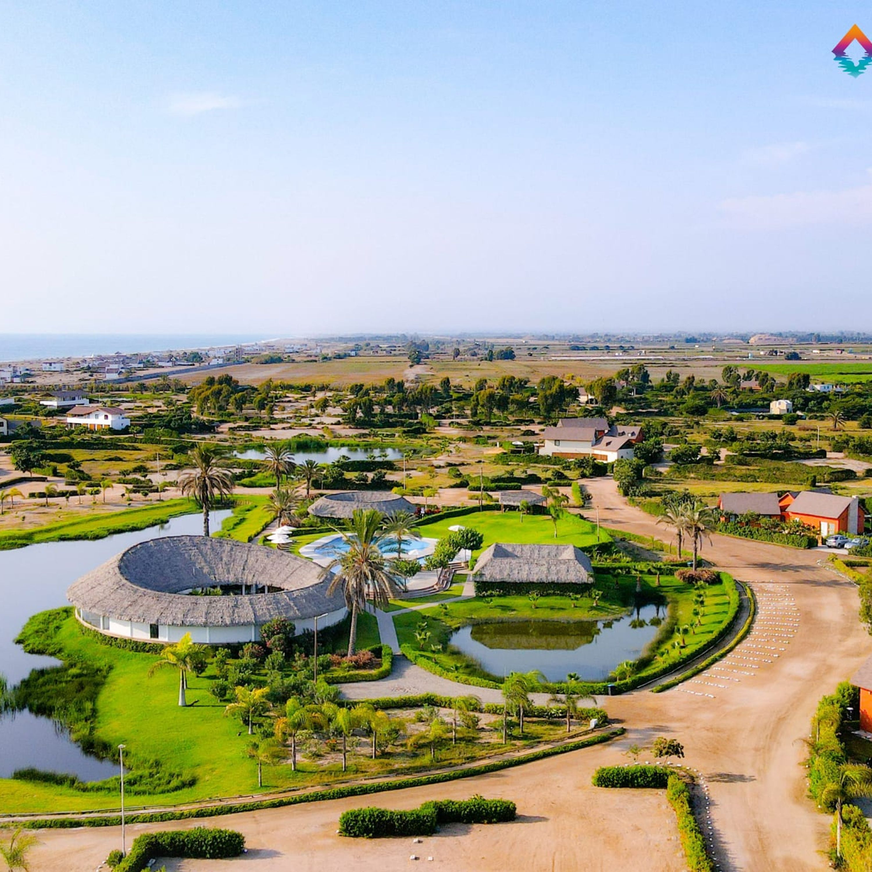 A resort with circular buildings, a central water feature, and a well-maintained landscape.
