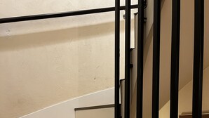 Una escala amb graons de fusta i barana de metall negre.