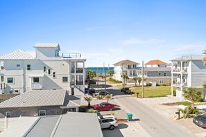 A coastal residential area with modern houses, a clear view of the ocean, and a street with parked cars. - Beach House - The Sandcastle by PHG (Panama City Beach)
