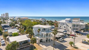 Una zona residencial costera con casas modernas, una playa y una vista despejada del océano.