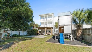 A two-story house with a covered patio and a blue slide. - Beach House - The Sandcastle by PHG (Panama City Beach)