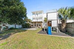 A two-story house with a covered patio and a blue slide. - Beach House - The Sandcastle by PHG (Panama City Beach)