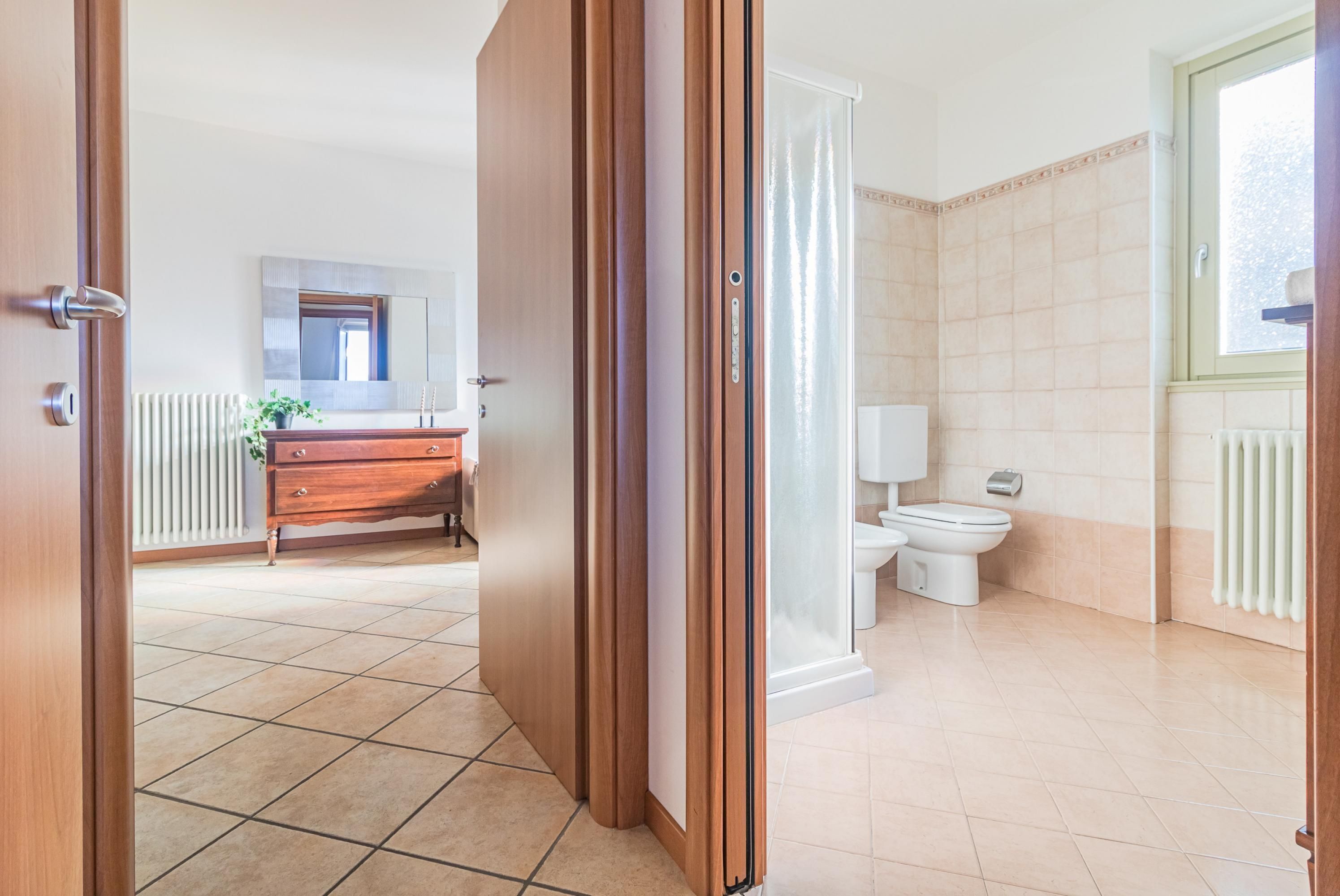 A bathroom with a toilet, a shower, and a sink.