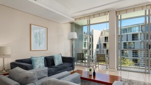 A modern living room with a grey sofa set, a coffee table, and a framed artwork on the wall. - Contemporary Cape Town Gem- No Loadshedding (Cape Town)