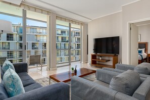 Relax in this stylish living room with a large flat-screen TV, comfortable sofa, and a beautiful view.