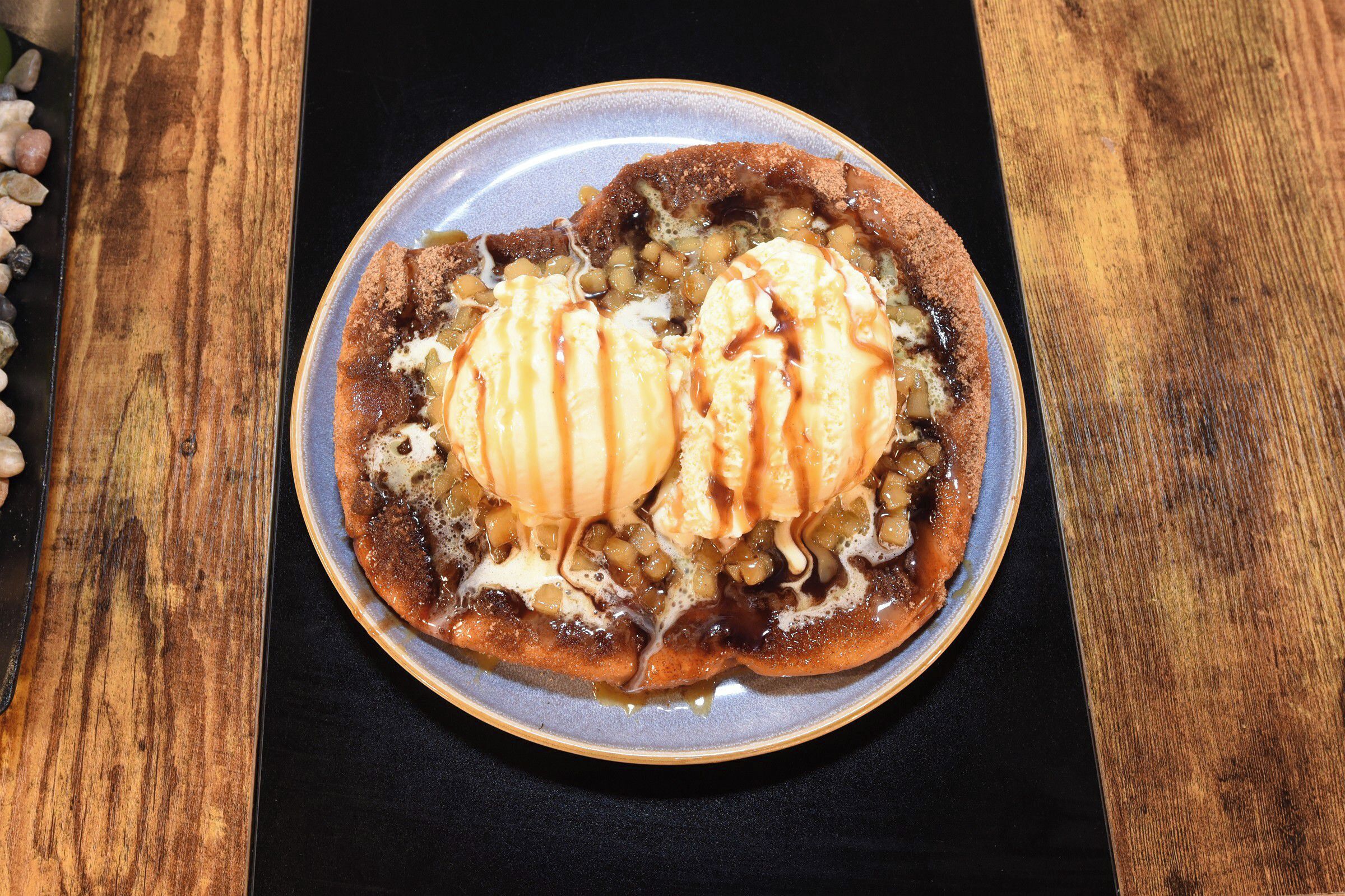 Sobremesa em um prato com caramelo e sorvete.