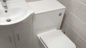 A bathroom with a white sink, toilet, and cabinet. - 2 Bed Chalet Sleeps 5 - Pets, Parking, Near Beach (Great Yarmouth)