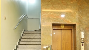 Una escalera con barandilla de metal que conduce a una puerta de madera con un ascensor etiquetado como 'LIFT'.