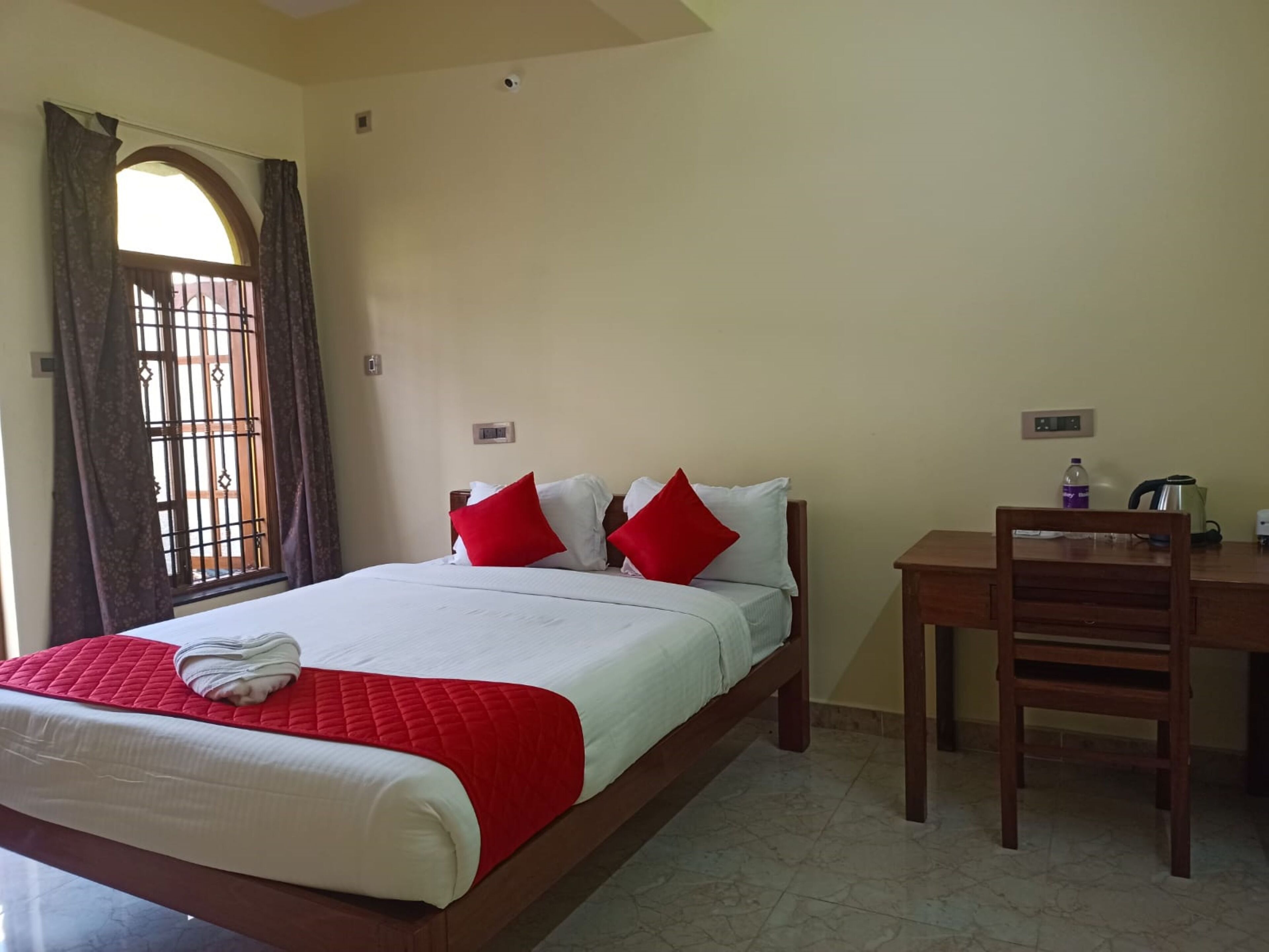 Una camera d'albergo con un letto, una scrivania e una sedia.