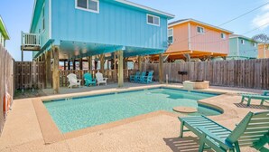 A backyard with a pool, wooden deck, and outdoor seating. - `Enjoy the Sun in Your Private Pool, Charcoal Grill & Fire Pit for Cozy Evenings – Free Golf Cart, Private Pool, Just Steps from the Beach!` (Port Aransas)