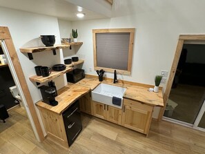 Une cuisine compacte avec des meubles en bois, un évier encastré et un four à micro-ondes.