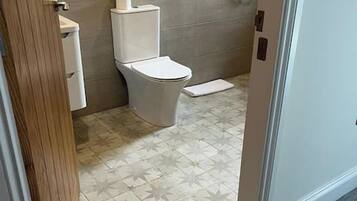 A bathroom with a toilet, a sink, and a shower.