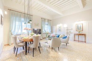 Un salon spacieux comprenant un coin repas, un canapé et un téléviseur.