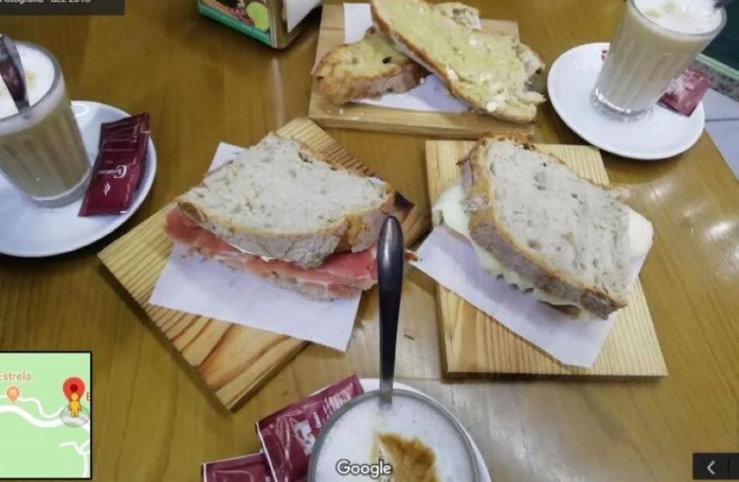 Une table avec des sandwichs, un verre de lait et une cuillère.