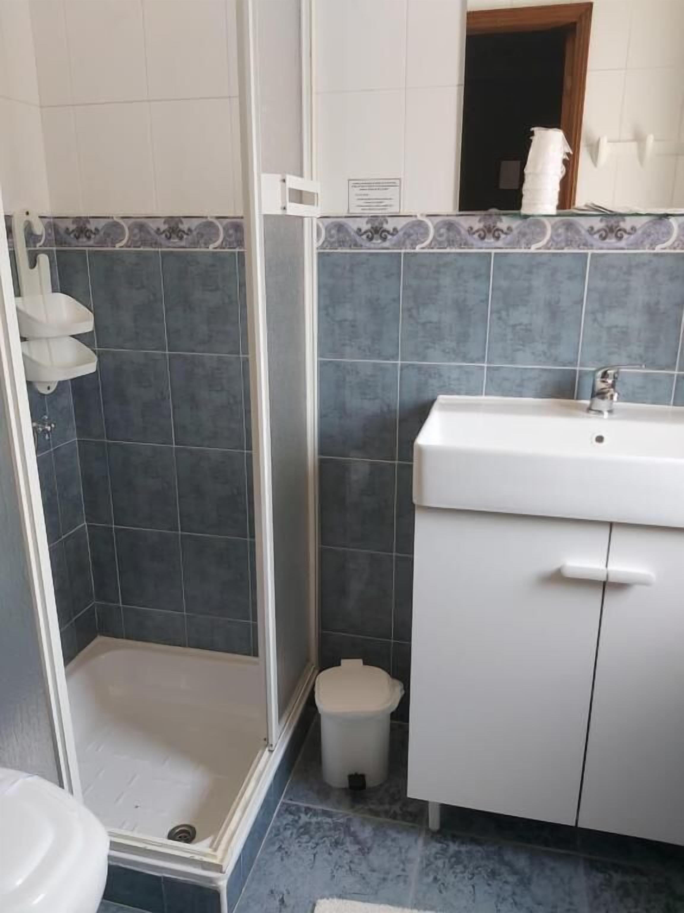 A bathroom with a shower, toilet, and sink.