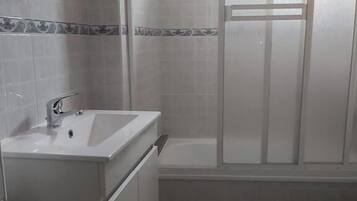 A bathroom with a white sink, a bathtub, and a toilet.