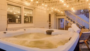 A hot tub with a wooden chair and a towel, surrounded by a wooden deck and a staircase. - 3 Mins to ND. Hot Tub, Game Room, Sleeps 16, Fire Pit (South Bend)