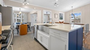A modern kitchen with a large island, stainless steel appliances, and pendant lighting. - 3 Mins to ND. Hot Tub, Game Room, Sleeps 16, Fire Pit (South Bend)