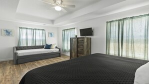 Ein Schlafzimmer mit einem Bett, einem Sofa, einem Fernseher und einem Kleiderschrank.