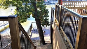 Eine Holztreppe führt zu einem Steg am Wasser.