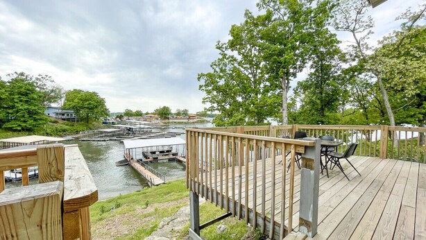 Une terrasse en bois offrant une vue sur une rivière et une zone de quai.