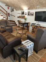 Una sala de estar acogedora con chimenea, televisor y comedor con mesa y sillas.