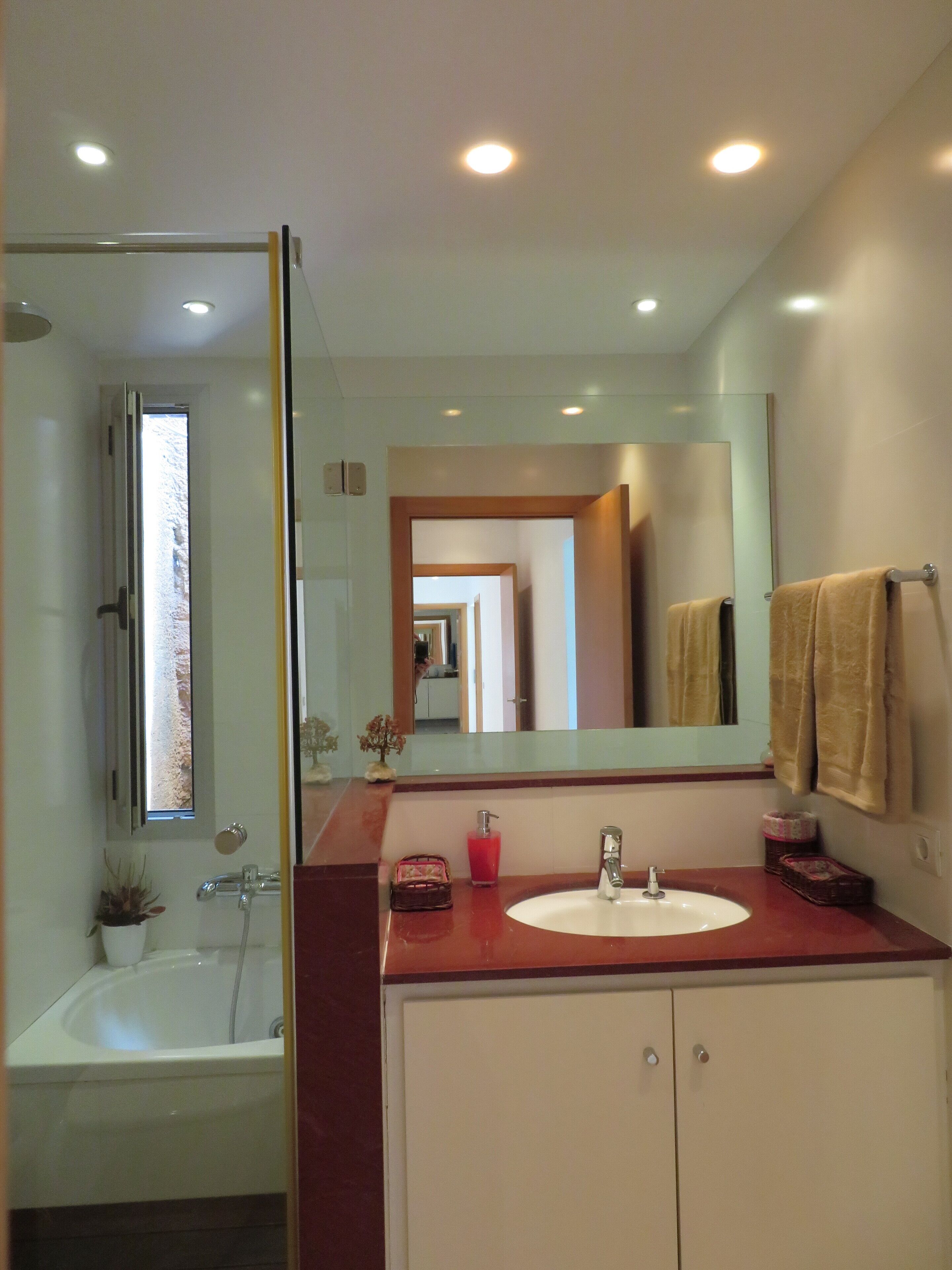 Une salle de bain avec une baignoire, un lavabo, un miroir et une douche.