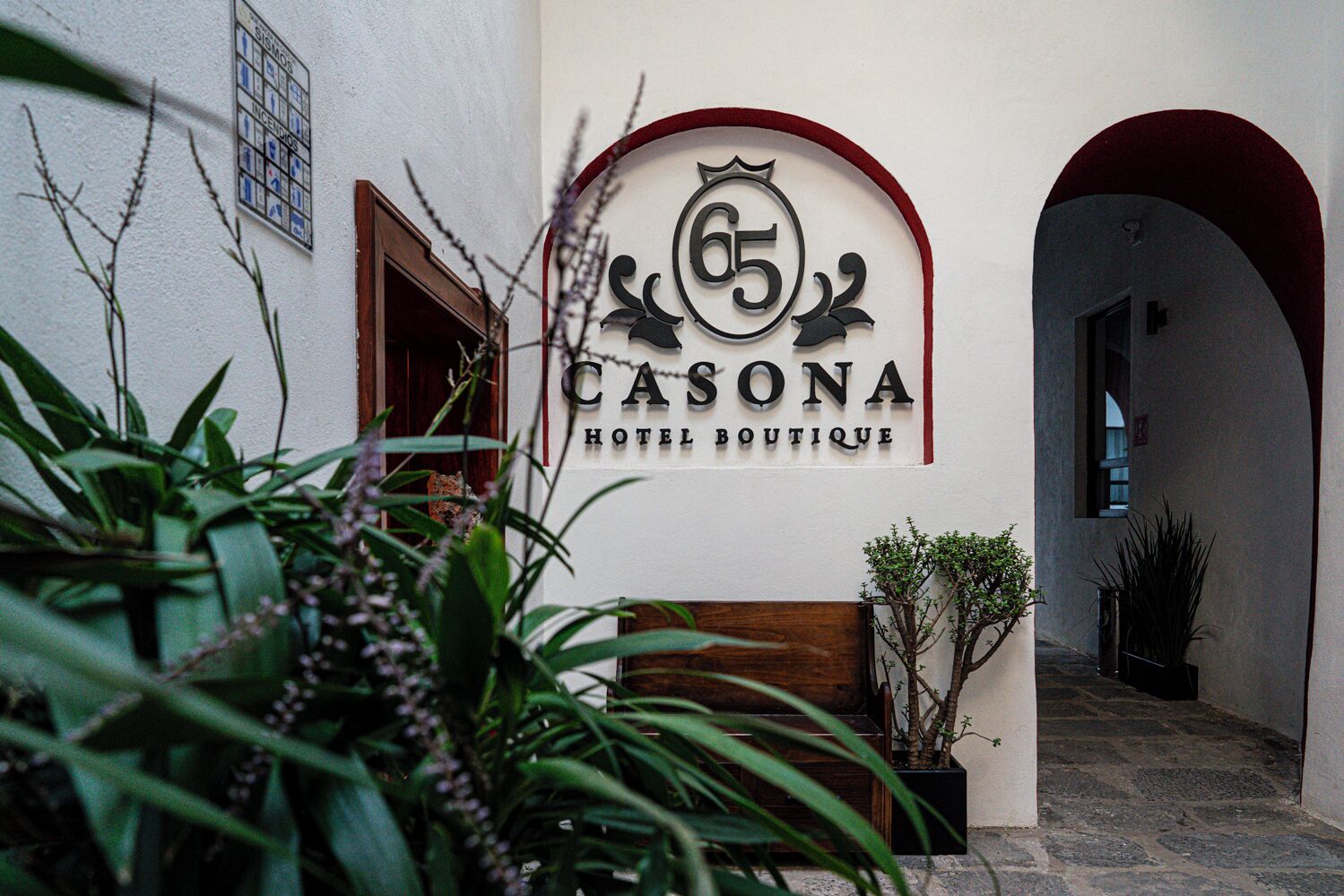 A hotel entrance with a sign reading 'CASONA HOTEL BOUTIQUE' and an arched doorway.