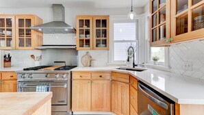 Une cuisine moderne avec des meubles en bois, une cuisinière en acier inoxydable et un lave-vaisselle.