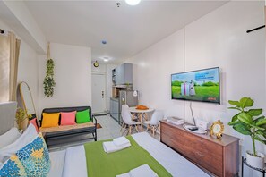 Une chambre d’hôtel comprenant un lit, un canapé, une télévision, un bureau et un coin repas.